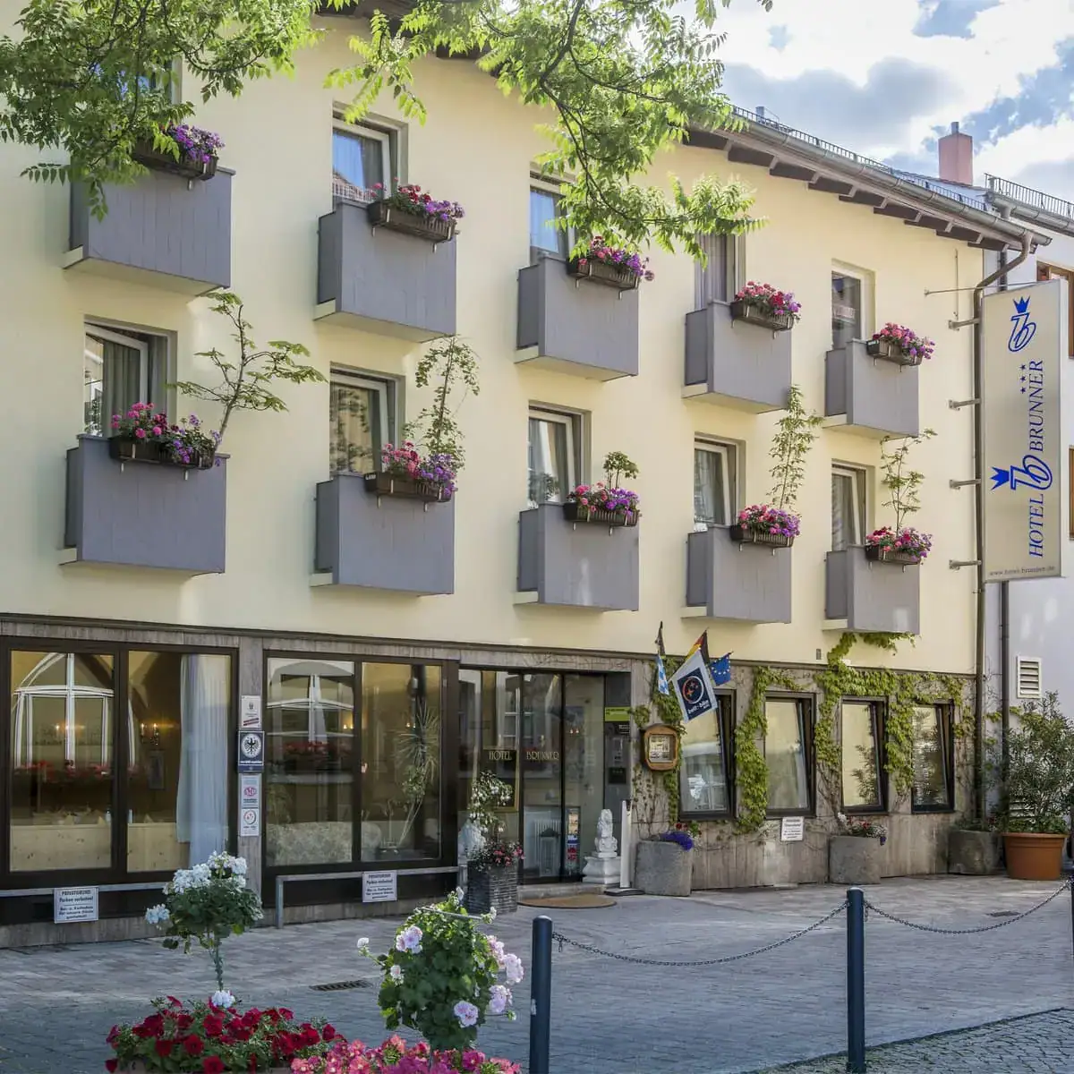 Die Vorderseite des Hotel Brunner in Amberg mit kleinen bepflanzten Balkonen.