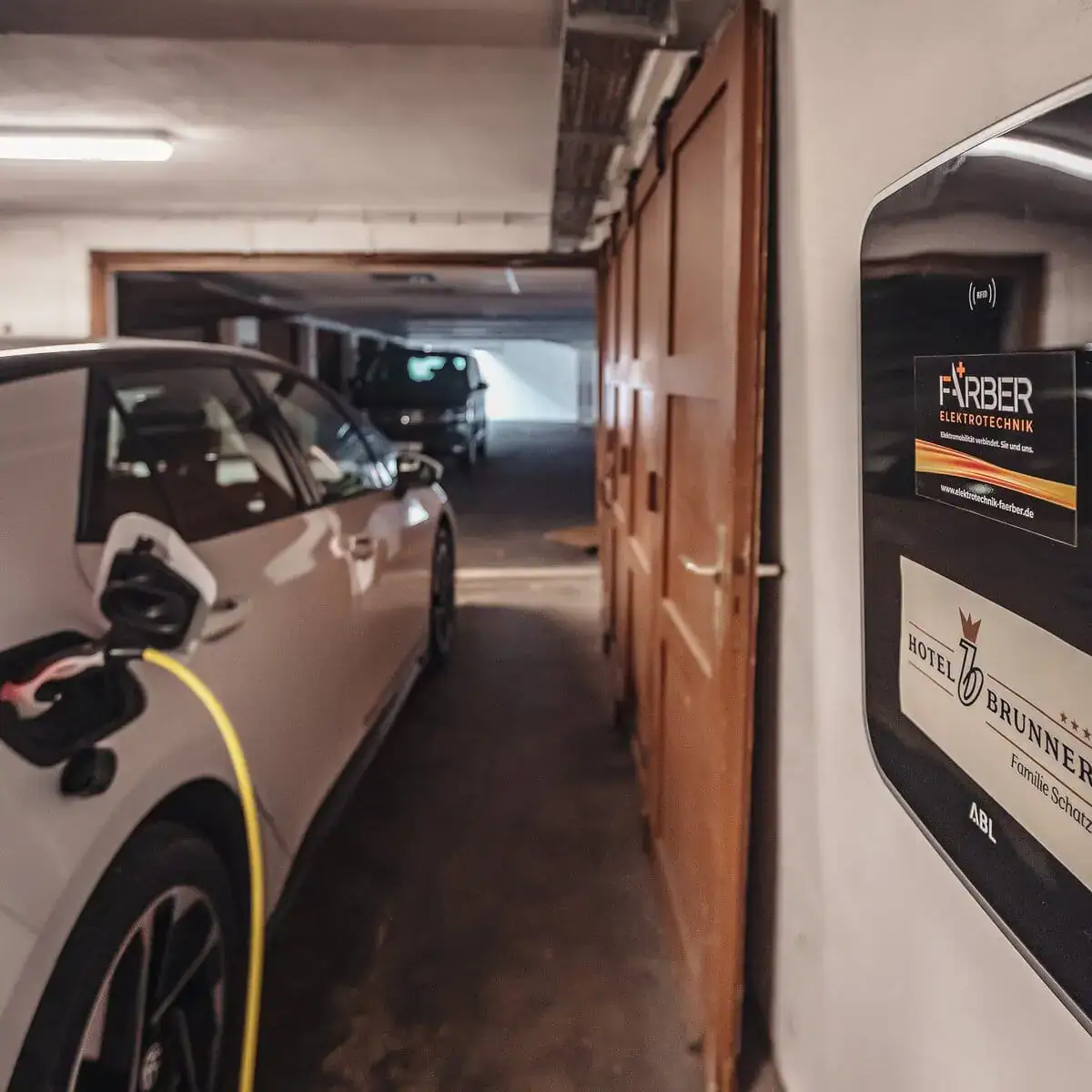 Garage im Hotel Brunner mit einem E-Auto, das gerade über die Wallbox geladen wird.